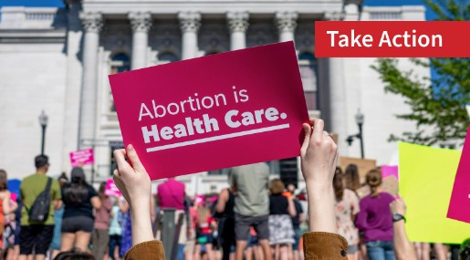 Person holding a pink sign saying “Abortion is Health Care”