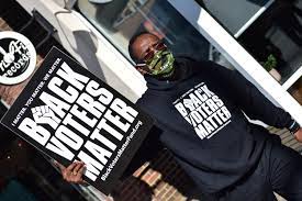 Black man holding Black Voters Matter (BVM) sign and wearing BVM sweatshirtPicture