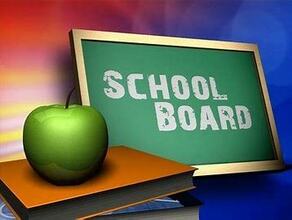Blackboard with School Board written on it next to a green apple on a book