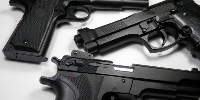 Three black handguns on a white background 