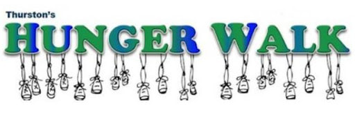  Green and blue logo for Hunger Walk with small shoes dangling from it.