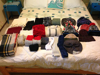  Folded warm weather clothing on a bed.